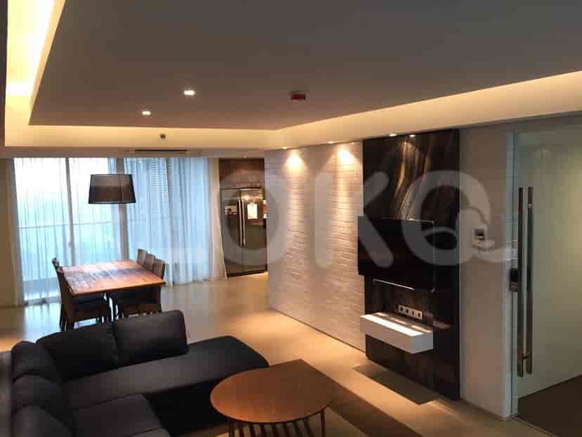 Modern living and dining space featuring a wooden dining table, a grey sofa, and a TV unit, with a sleek open design.