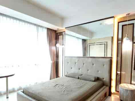 A bedroom with a large bed, mirrors, and curtains.
