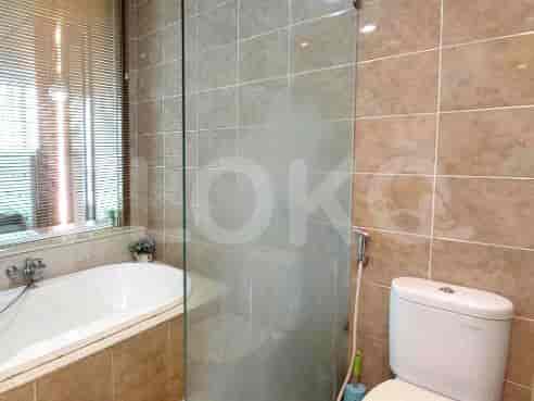 A bathroom with a shower and beige tiles.