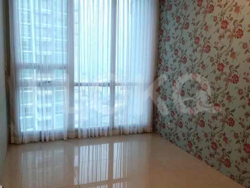 A bedroom with a bed and a large window.