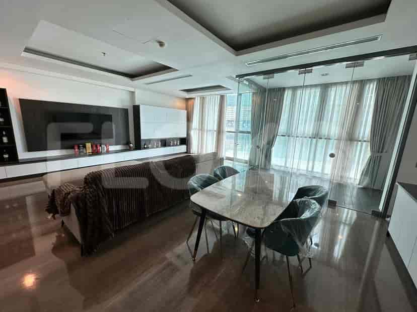 A modern living room with a grey sofa, a marble dining table, and large windows.