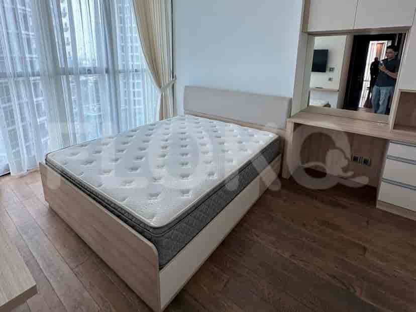 Bedroom with a bed, wooden flooring, and large windows.