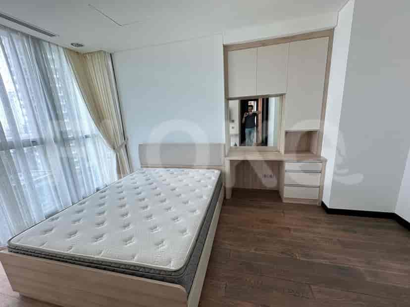 Bedroom with a bed, a desk, and a large mirror.