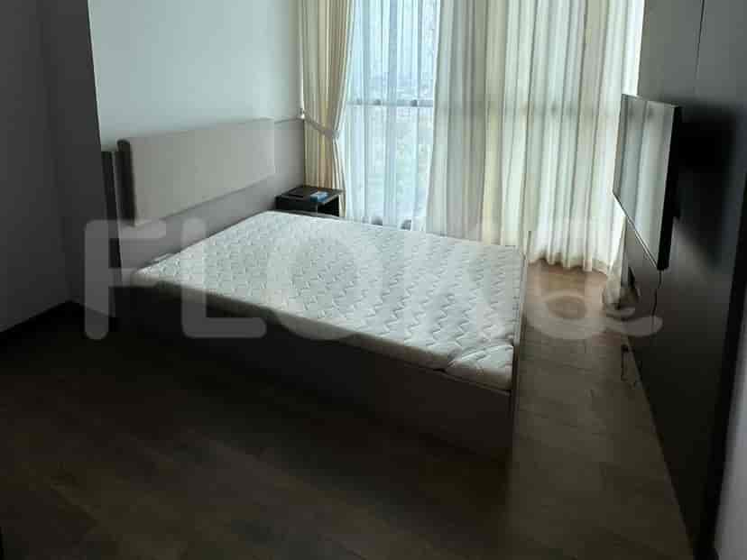 Bedroom with a bed, a nightstand, and a large window.