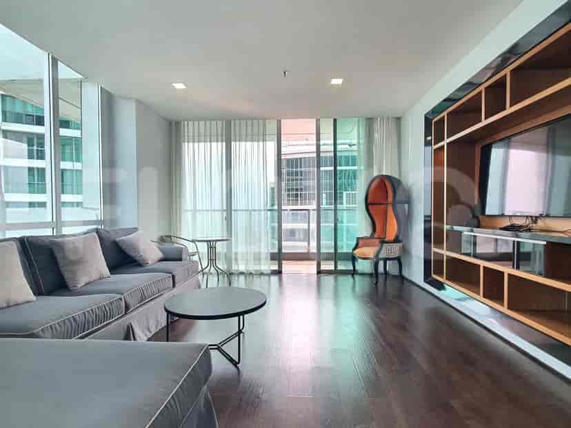 A modern living room with a large L-shaped sofa, entertainment unit, and city views.