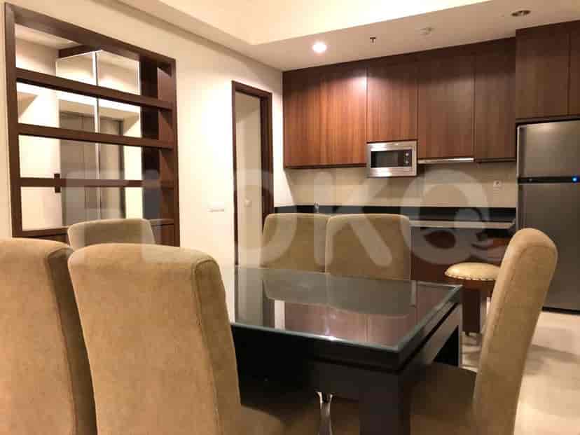Dining area with a table, chairs, and a view of the kitchen.