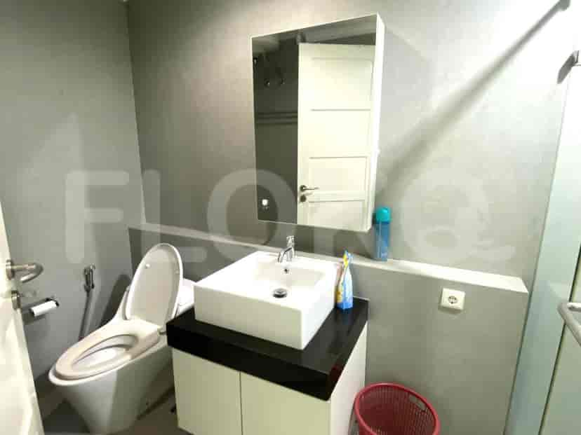 Small bathroom with a toilet, sink, and a mirror.