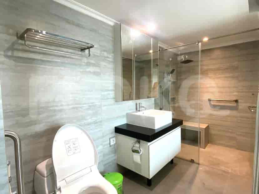 Modern bathroom with a glass shower, toilet, and sink.