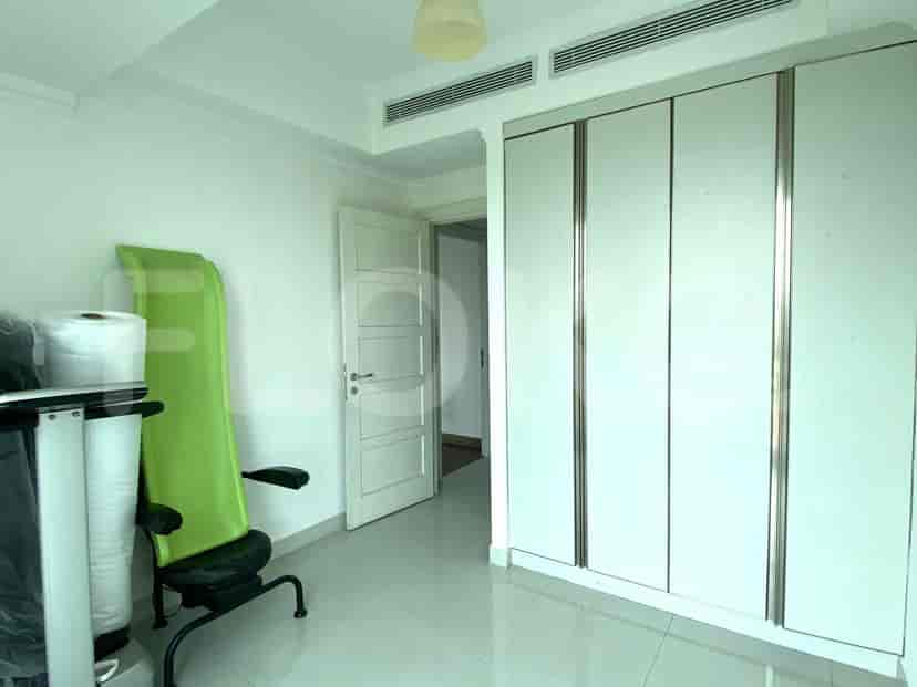Small room with a chair, a green exercise equipment, and wardrobe.