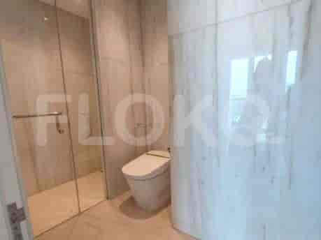 Bathroom with a glass shower and marble walls.
