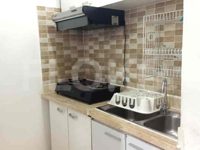 A kitchen with a gas stove, sink, and cabinets.