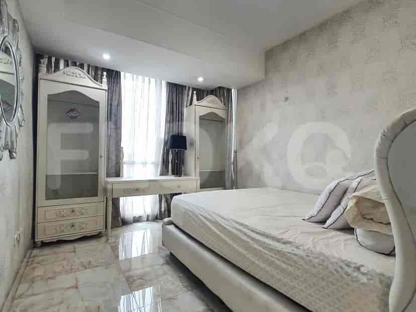 A bedroom with a double bed, bedside tables, and wardrobes.