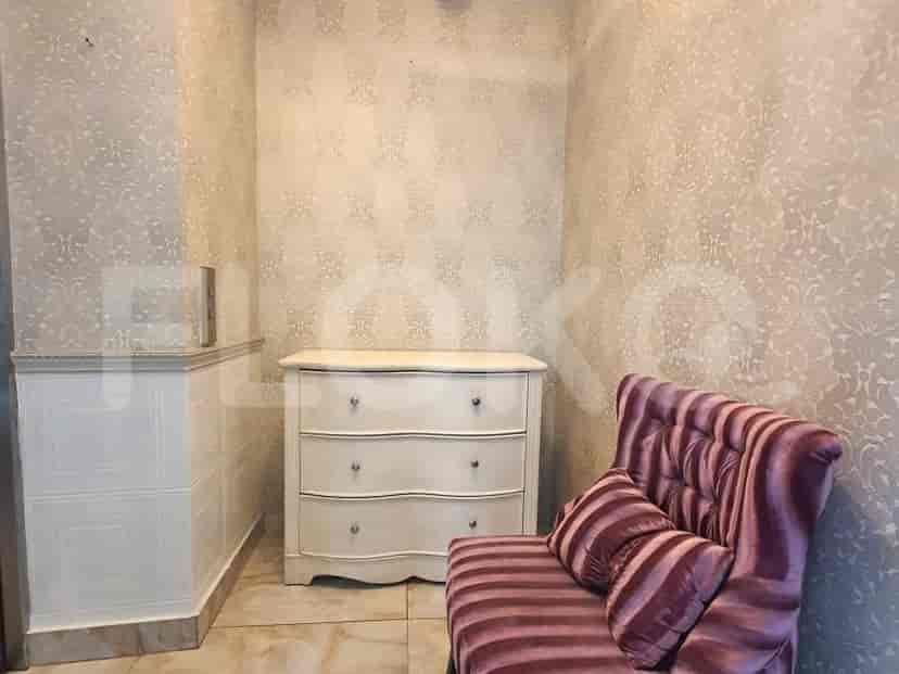A hallway with a chest of drawers and a small sofa.