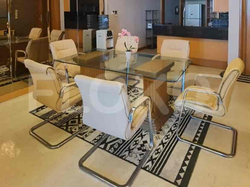 A dining area with a glass-topped table and chairs.