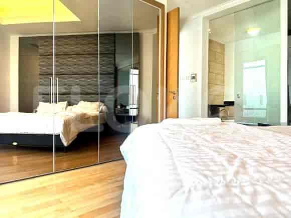 Elegant bedroom with large mirror closets and a queen-sized bed.