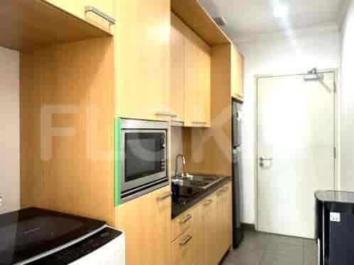 Compact modern kitchen with appliances and wooden cabinetry.