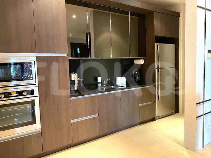 Dapur modern dengan lemari kayu gelap dan peralatan baja tahan karat.