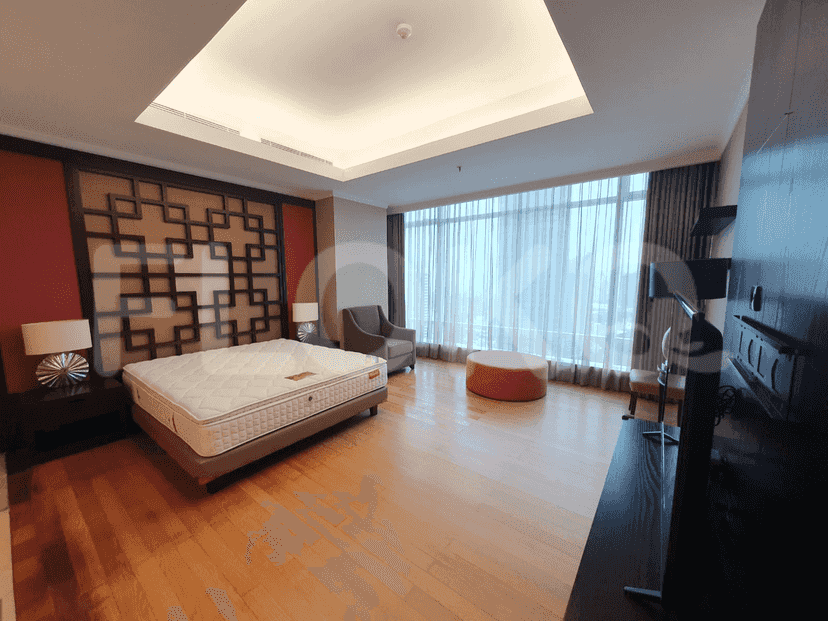 Bedroom with bed, bedside tables, and large window.