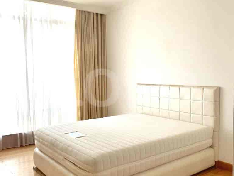 A bedroom with a queen bed, neutral-toned curtains, and bright natural light.