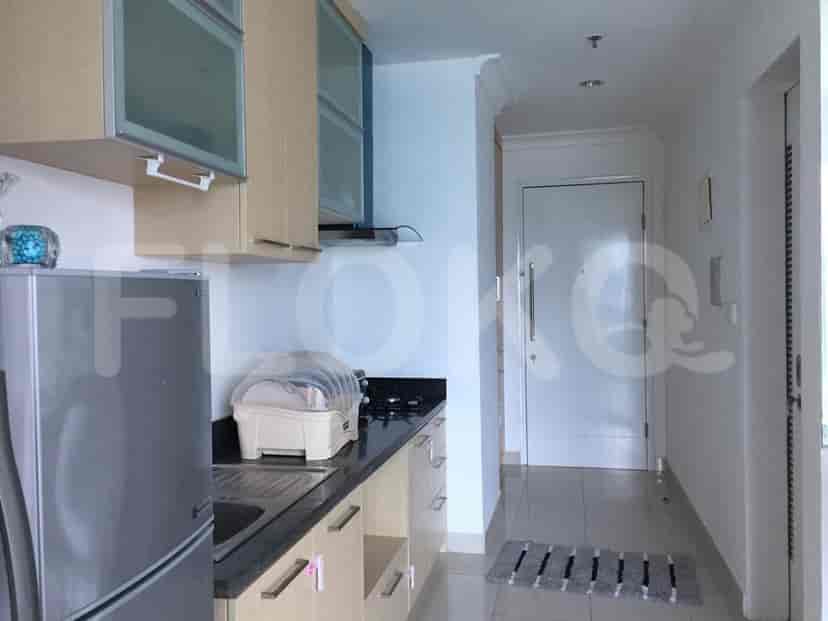 A modern kitchen with stainless steel appliances and light wood cabinets.