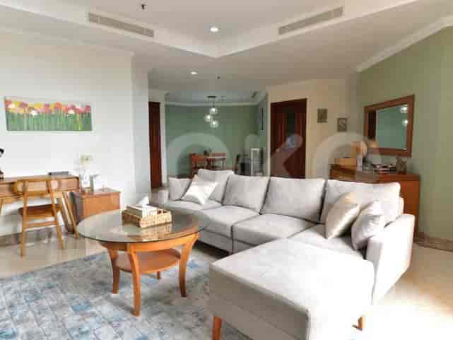 Spacious living room with grey sectional sofa, glass coffee table, and wall art.