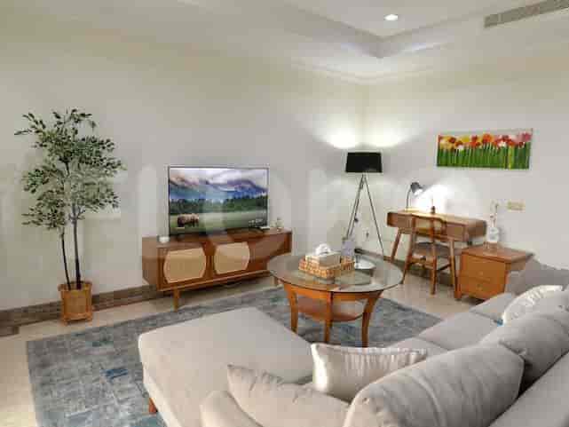 Living room with wooden TV stand, smart TV, and sofa.