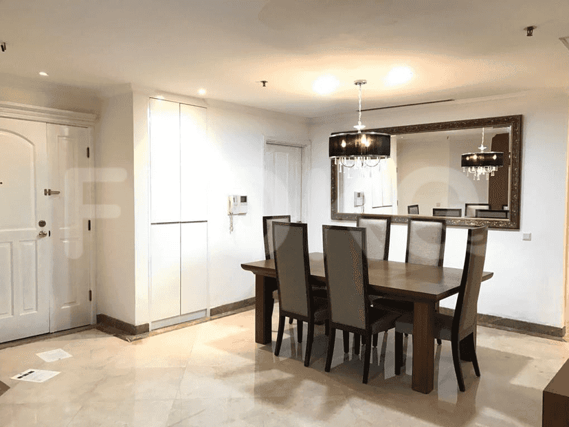 Dining area with a wooden table, chairs, and a large mirror.
