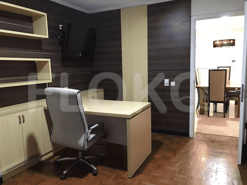 Home office with a desk, chair, and built-in shelves.