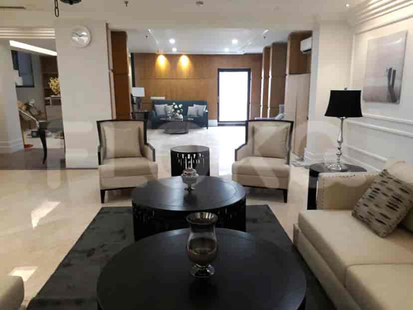 A welcoming entrance with a sofa, armchairs, and dark wood coffee tables.