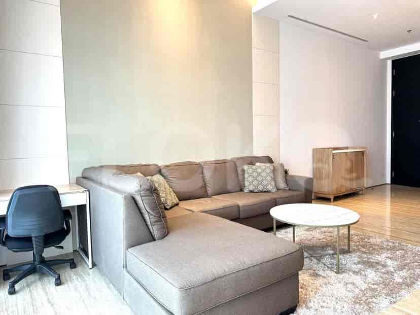 A modern living room featuring a large L-shaped sofa, desk and a round coffee table.