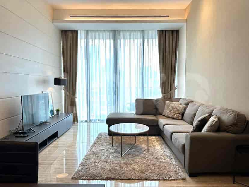Spacious living room with a large sofa, smart TV, and floor-to-ceiling windows.