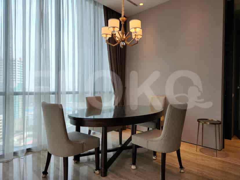 Dining area with a large oval table, chairs, and a stylish chandelier.