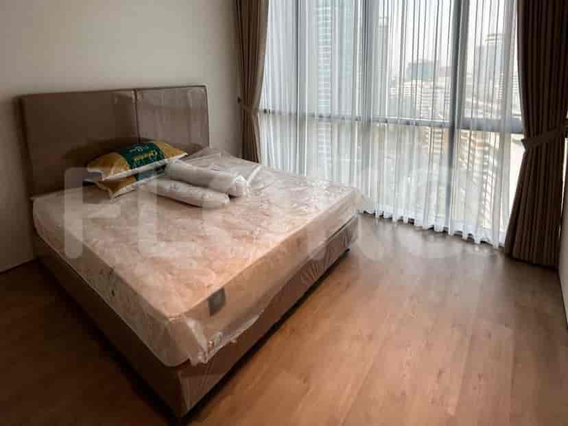 Bedroom with a bed, large windows, and neutral tones.