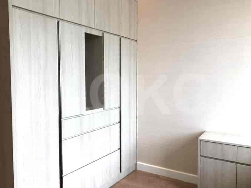 A bedroom with a large wardrobe, neutral walls, and a simple aesthetic.