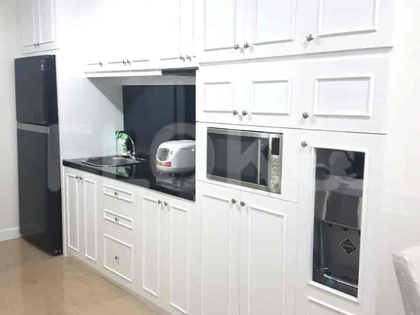Modern white kitchen with black countertop, stainless steel appliances.
