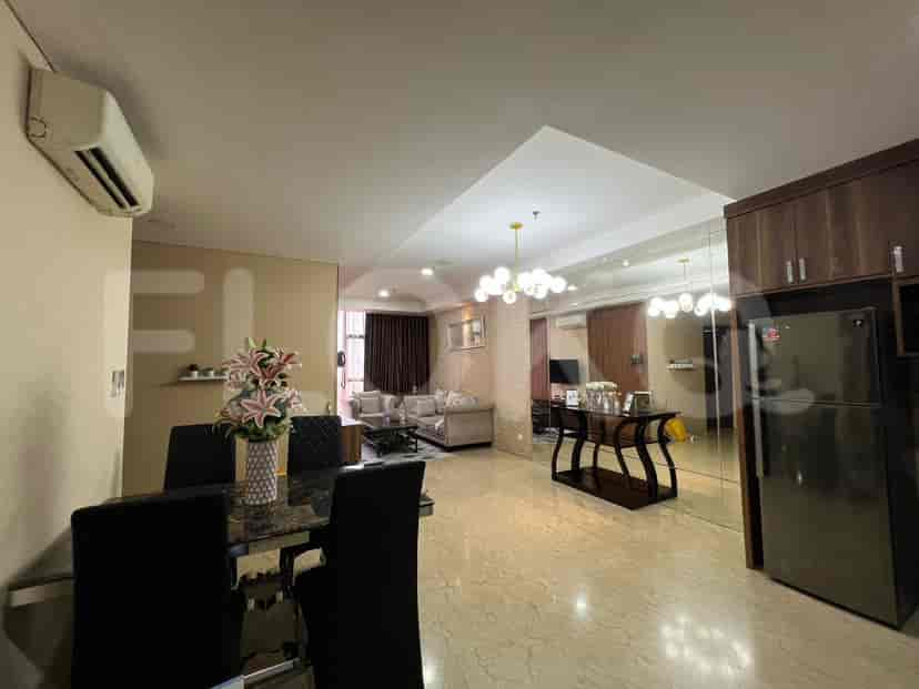 Open-plan living and dining space with a table set for dining and a glimpse of the living area.