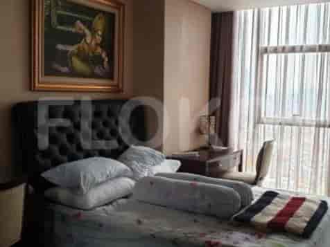 A bedroom with a bed, a painting above it, and a large window.
