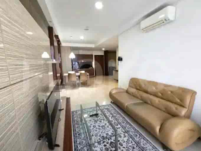 Spacious living room with tan leather sofa, glass coffee table, and patterned rug.