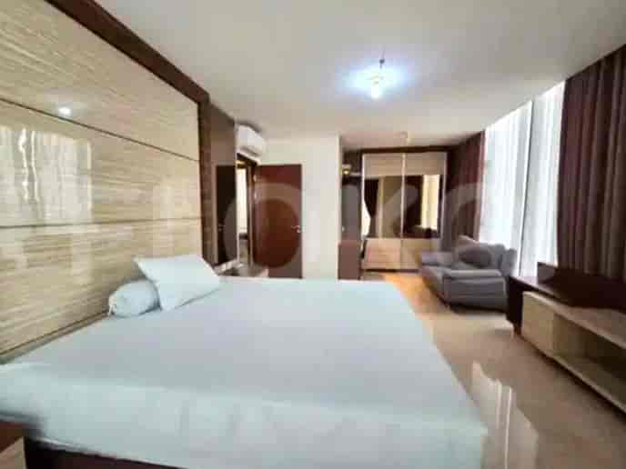 Bedroom with a bed, a small sofa, and a large closet.