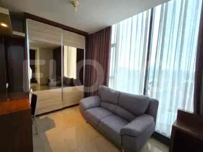 Bedroom with a bed, sofa, and large windows with curtains.