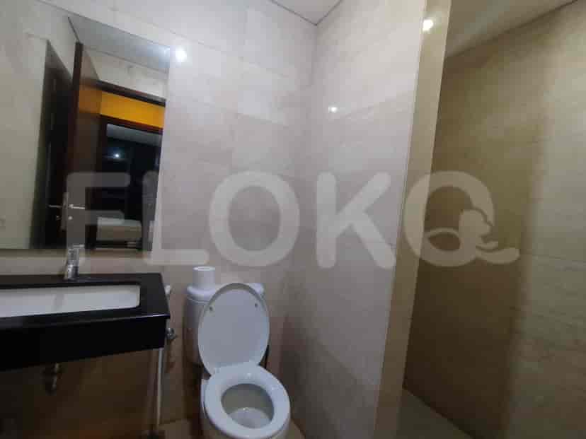 A modern bathroom featuring a toilet, sink, and neutral-toned tiles.