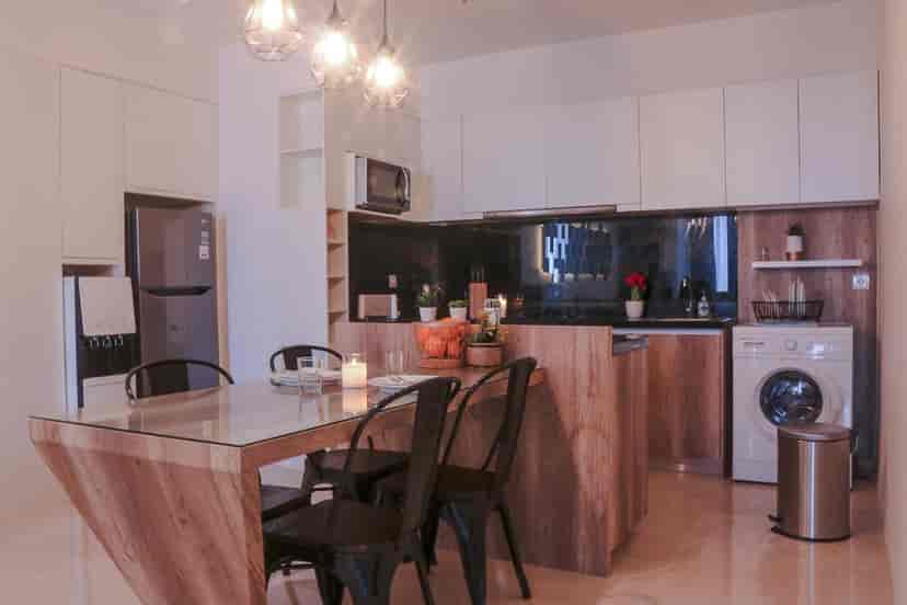 Modern kitchen with wooden cabinetry, island, and dining area.