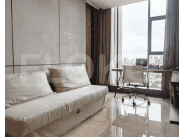 Area ruang tamu kecil atau kantor rumah dengan sofa dan meja dekat jendela.
