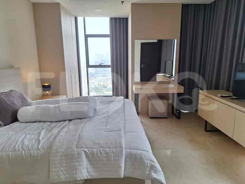 A well-lit bedroom featuring a double bed, large window and a dressing table.