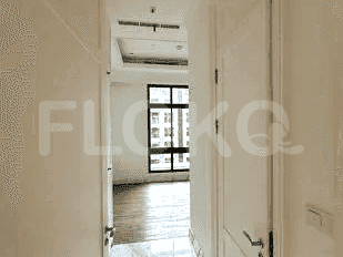 A hallway with a door and views of the living room.