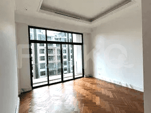 A bedroom with wooden flooring and large windows.