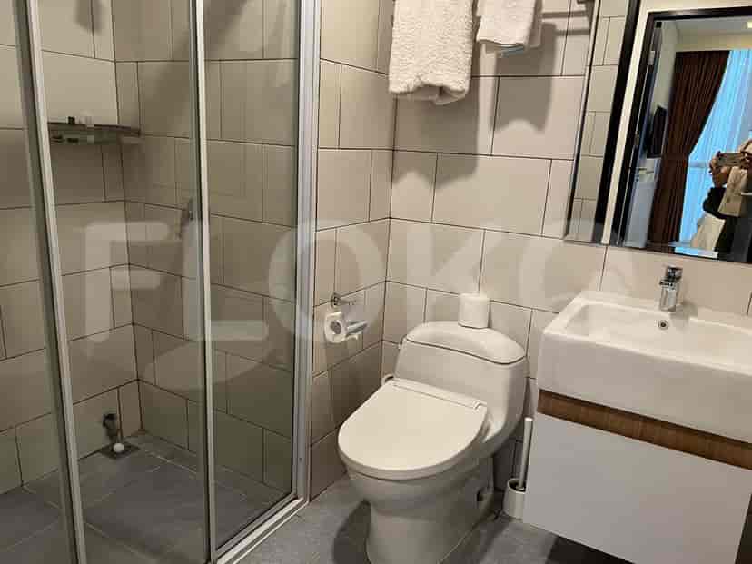 A bathroom with a toilet, shower, and sink.