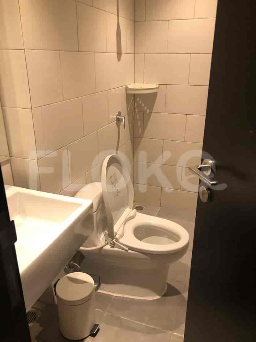 Kamar mandi modern dengan toilet dan wastafel.