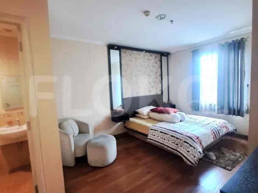 Bedroom with a large bed, armchair, and window.