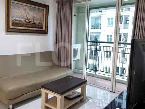 A furnished living room with a sofa, coffee table, and balcony access.
